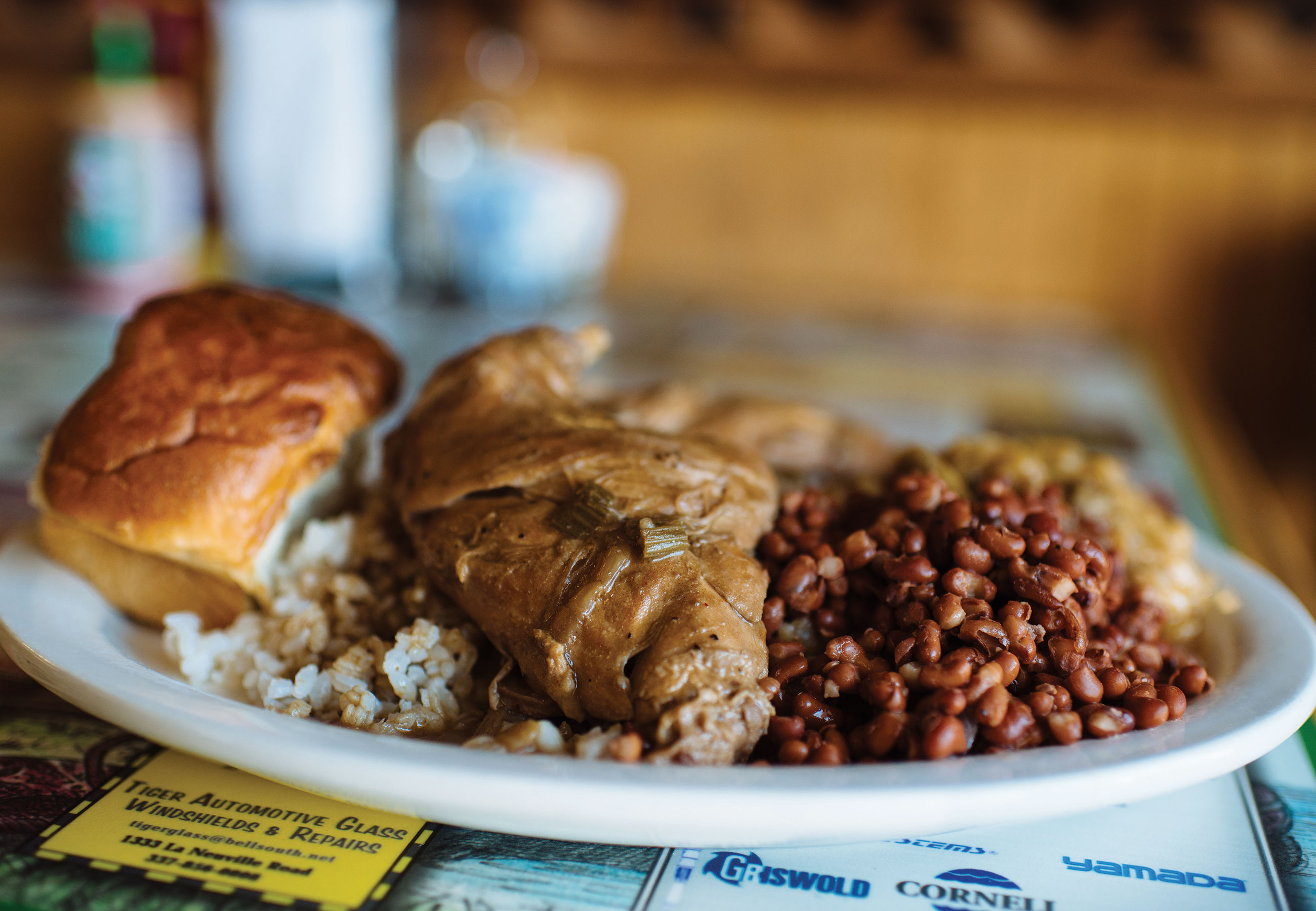 White plate of soul food piled with beans, rice and bread