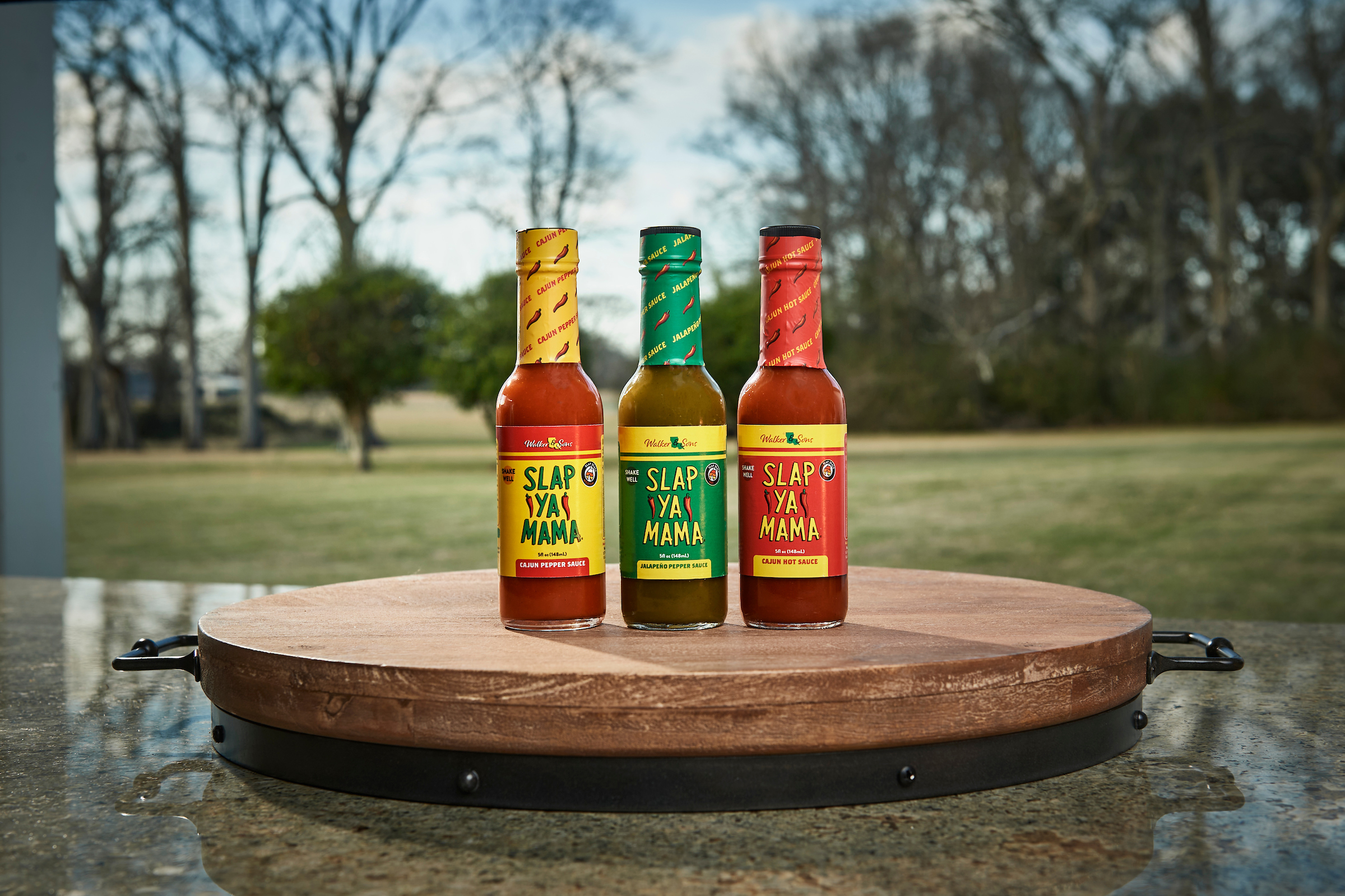 Three bottles of Slap Ya Mama hot sauce.