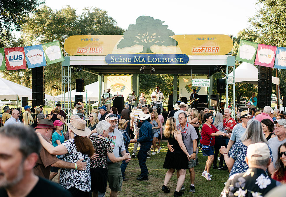 Dozens of people dance before a stage.