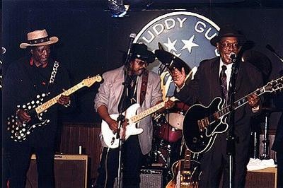 Buddy Guy, Jimmy D. Lane and Jimmy Rogers playing at Guy's Legend's club in 1996. Courtesy of Wikimedia Commons.