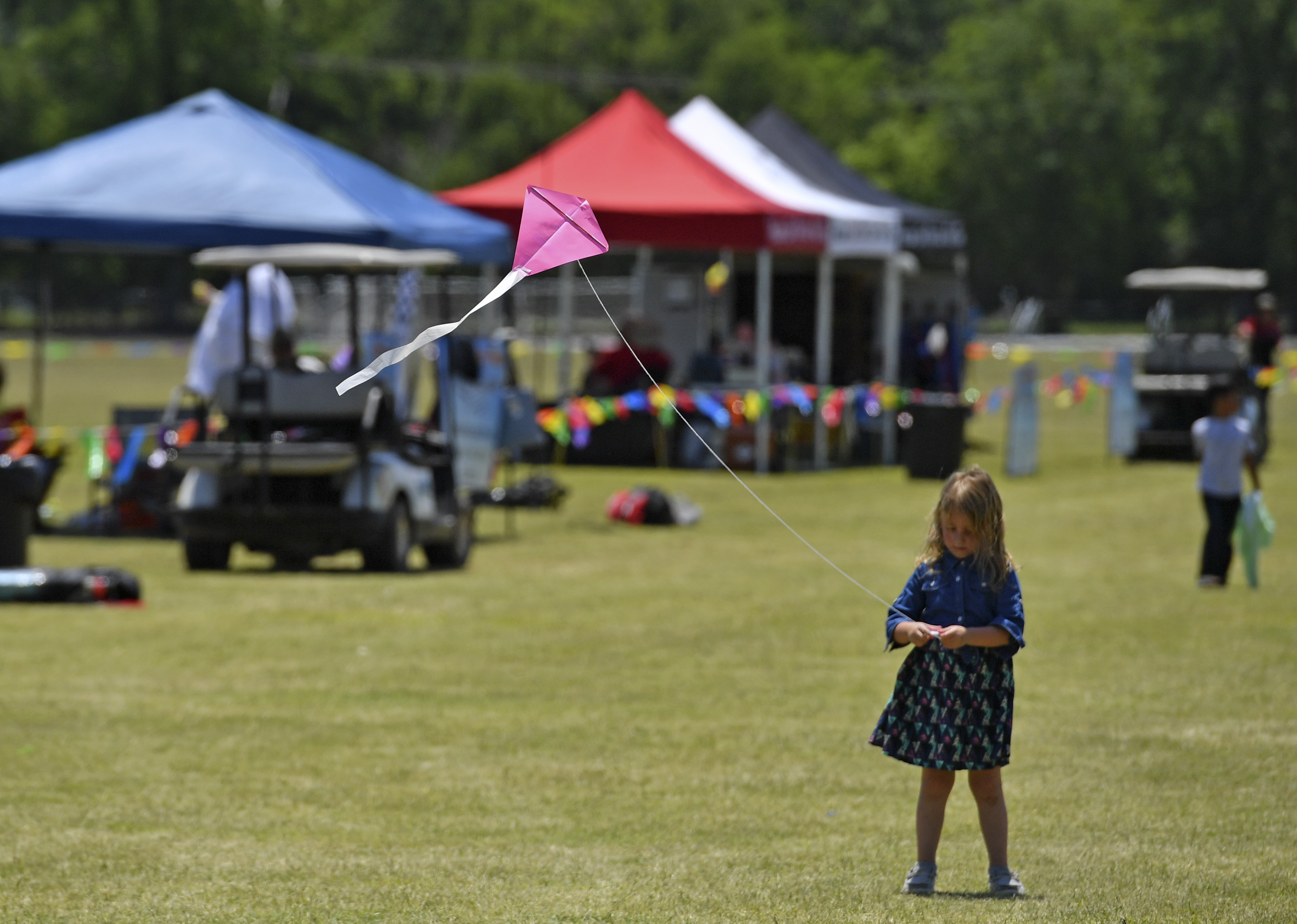 Young girl flying a kite at Kite Fest Louisiane'.