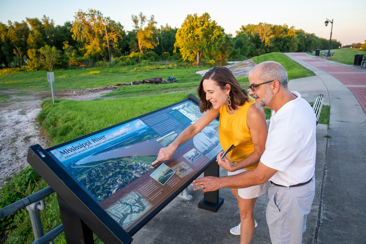 Two people read a historical marker about the Mississippi River.