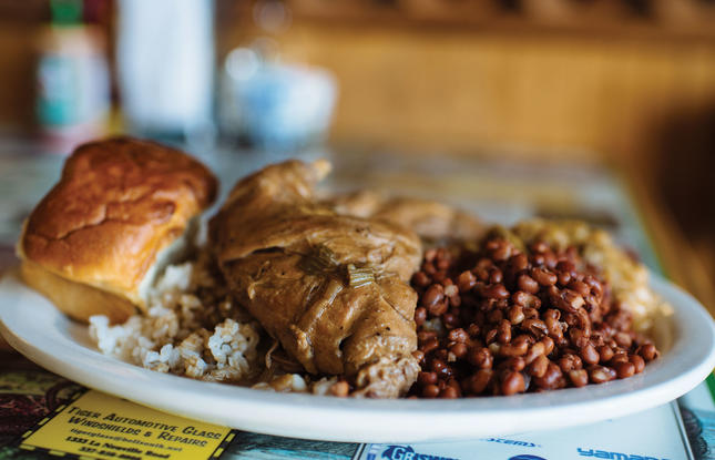 White plate of soul food piled with beans, rice and bread