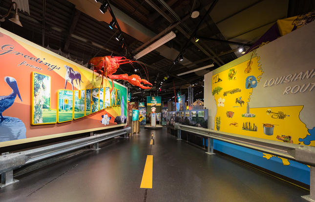 The interior of Capitol Park Museum, featuring a map of the state and a giant crawfish above a postcard graphic.
