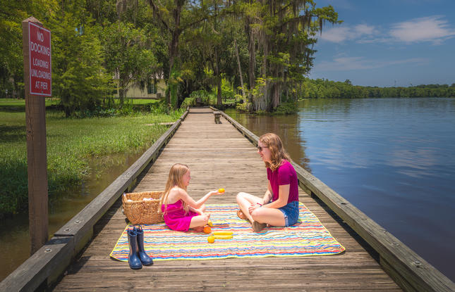 A mother and daughter enjoy a picnic lunch on the boardwalk at Fairview-Riverside State Park.