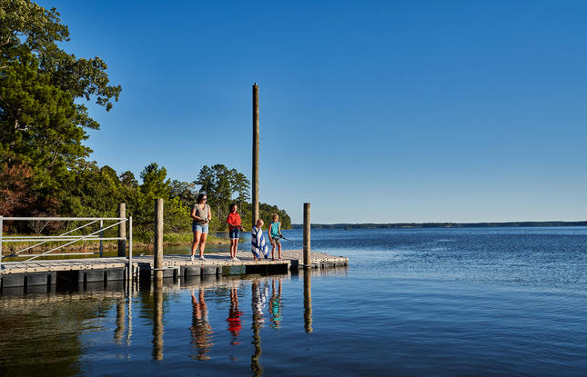 A family fishes from the boardwalk at South Toledo Bend State Park, with a beautiful view of the reservoir in the background.