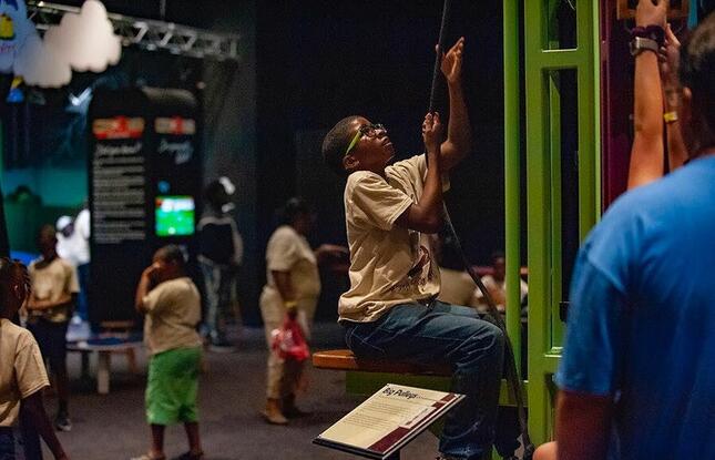A child climbs a rope in an indoor play area at Sci-Port Discovery Center.