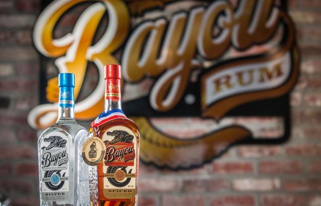 Bottles of white and dark rum against a brick wall at Bayou Rum in Lacassine, Louisiana.