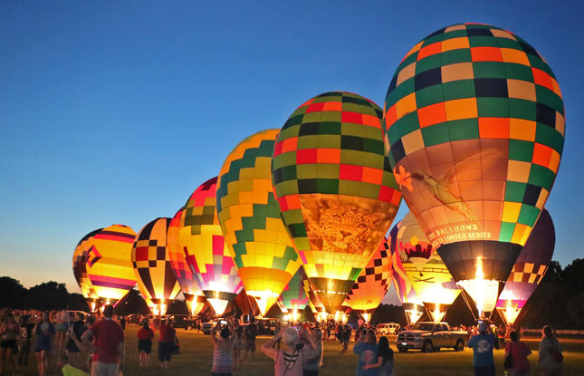 See the Red River Balloon Rally glow at night.