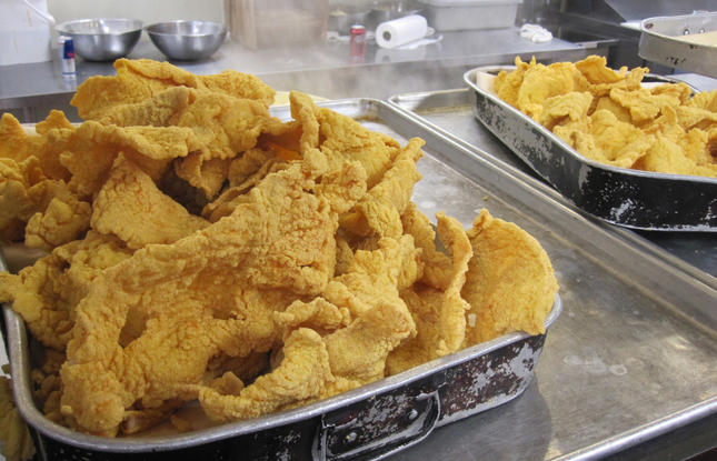 Trays of freshly fried, well seasoned catfish sit in a Louisiana kitchen.