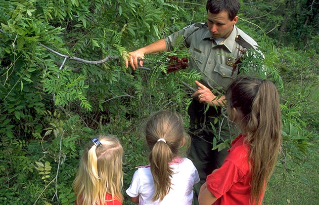 A park ranger shows a plant to children at the Lake Claiborne Nature Walk in Louisiana.Lake Claiborne Nature Walk