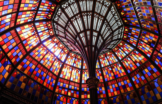 Louisiana's Old State Capitol stained glass rotunda, with the sun shining through shades of blue, yellow, red and orange.