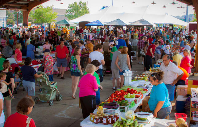 Local vendors selling produce and goods, with shoppers surrounding the area at the Shreveport Farmers Market in Louisiana.