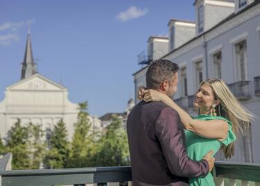 A couple embraces in front of the St. Louis Cathedral in New Orleans.
