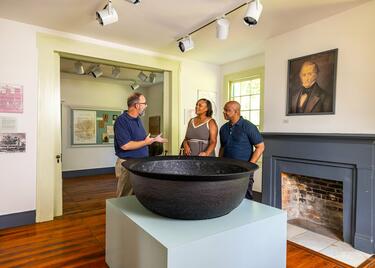A tour guide provides information to a middle-aged couple at the E.D. White Historic Site in Louisiana.
