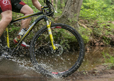 A cyclist traverses a muddy trail in Lincoln Parish Park.