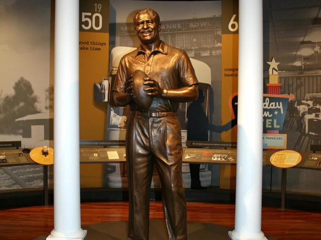 A bronze statue of Coach Rob stands in the cente of one of the exhibit rooms.