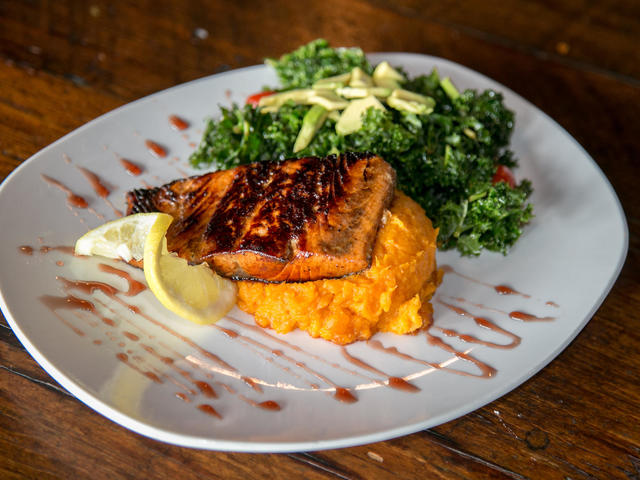 Atlantic Salmon marinated in pure cane syrup with a soy spiced glaze, over Louisiana sweet potato mash with bacon jam and a fresh kale salad