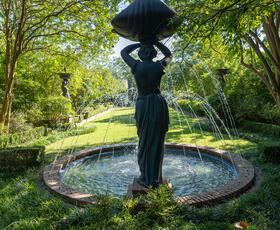 A garden fountain in the shape of a woman at the Biedenharn Museum &amp; Gardens.