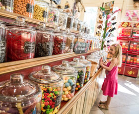 A little girl smiles in awe at rows of candy-filled jars at The Candy Bank. Credit: Louisiana Northshore
