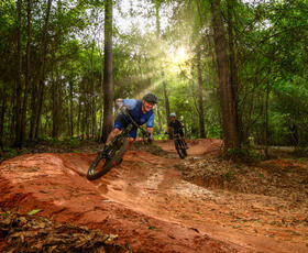Two people enjoy the muddy mountain-biking trails at Bogue Chitto State Park.