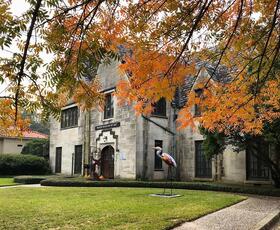 Pumpkin-orange leaves and a heron statue welcome visitors to the Masur Museum of Art in Monroe, Louisiana.