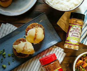 Poached eggs, shrimp and seasonings are strewn across a table.
