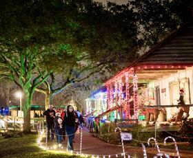 Cabins decorated in red-and-green Christmas lights during the Noel Acadian au Village.