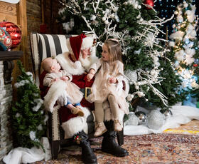 A child and a baby sit on Santa's lap in Santa's Christmas Village in Monroe, Louisiana.