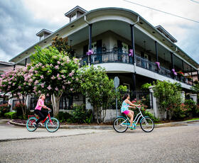 Two people ride bicycles.