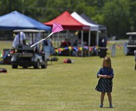 Young girl flying a kite at Kite Fest Louisiane'.