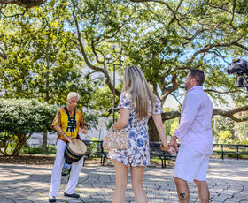 Musician playing music for a couple in the Congo Square in New Orleans.