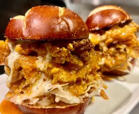 an onion-ring-covered burger from Plantry Cafe in Baton Rouge drips with sauce