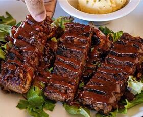 barbecue-sauce-covered jackfruit ribs sit on a bed of lettuce at Veganish Vibes in Baton Rouge