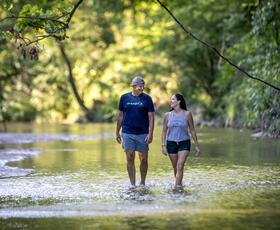 A couple walks through ankle-deep water in the forests of the Tunica Hills Wildlife Management Area.