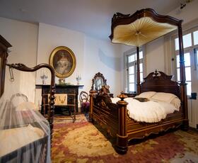 An ornately furnished bedroom at 1850 House.
