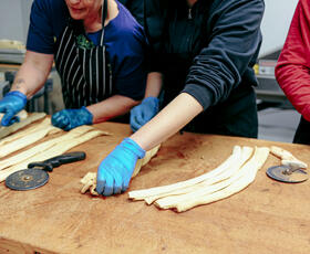 Bakers twist and fold king cake dough.
