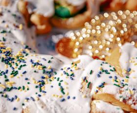 A close up of sprinkles on a king cake.