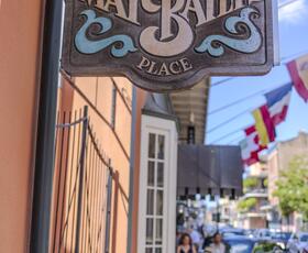 A handpainted wooden sign advertising May Baily’s Place hangs outside the Dauphine Hotel in New Orleans.