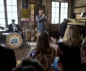 Audience applauds as a trumpet player performs with the Preservation Hall Jazz Band.