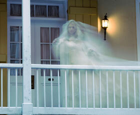 A female ghost wearing a wedding gown stands on a balcony at the Dauphine Orleans Hotel in New Orleans.