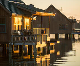 The cabins at Poverty Point Reservoir State Park sit on stilts directly above the water, offering a gorgeous golden-hour view.
