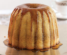 A moist rum-soaked pound cake, topped with a caramel-like sauce running down the sides of the cake.