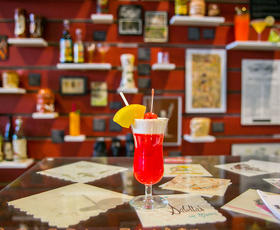 A bright red cocktail topped with whipped cream and pineapple at the Southern Food &amp; Beverage Museum in New Orleans.