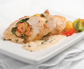 A tender chicken breast stuffed with flavorful crawfish, served with a creamy, herby sauce and topped with herbs.