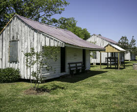 A white wooden cabin with a red roof at Frogmore Cotton Plantation &amp; Gins.