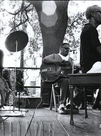 Professor Longhair sits at a piano on stage with his dreamy and bass player