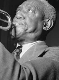 A side view of bunk blowing into his trumpet