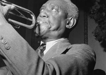 A side view of bunk blowing into his trumpet
