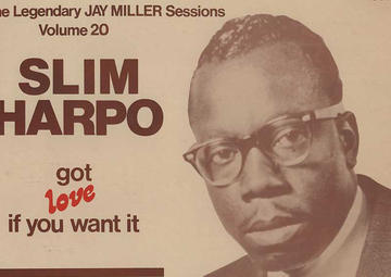 A sepia-toned album cover of Slim Harpo's "Got love if you want it." Slim, wearing black Ray Bans, looks toward the camera, wearing a dark suit and tie.